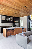 Modern open living room with wooden ceiling and kitchen island