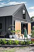 Woman and dog on the terrace in front of the black house