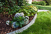 DIY metal and stone edging around flowerbed