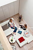 View down from gallery onto white, modular sofa in modern architect-designed house