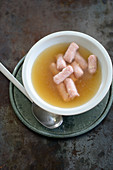 Mini Käsekrainer (cheese filled sausages) in a clear beef broth