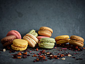 Bright fresh tasty macaron biscuits on grey board and dry fruits