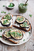 Toasts with fresh goat cheese, roasted eggplant and pesto