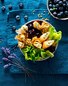A bulgur bowl with goat's cheese filo pastry rolls, blueberries, lettuce and lavender