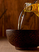 Oil being poured into a bowl