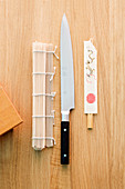 A bamboo mat, a knife and chopsticks