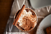 Cappuccino mit Kakao und Zimtstange