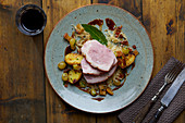 Leg of suckling pig with fried potatoes and grapes