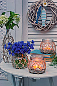 Cornflowers, hydrangeas and candle lanterns on garden table