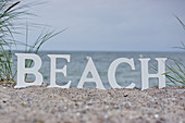 Letters spelling BEACH on beach