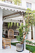 Überdachte Terrasse am exotischen Haus mit sommerlichem Garten