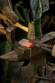 Blacksmith Hammers Red Hot Iron on Anvil