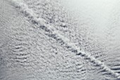 Aircraft contrail in altocumulus clouds