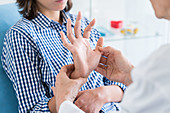 Doctor examining hands of a patient