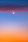 Waning crescent Moon and clouds at dawn