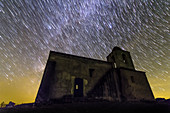 Star trails over Noudar Castle's church, time-exposure image