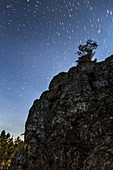 Star trails over cliff, time-exposure image