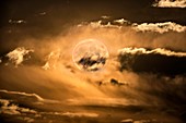 Supermoon rising behind clouds