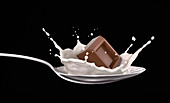 Chocolate cube splash in milk on spoon, illustration