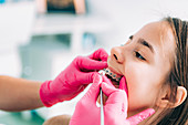 Orthodontist checking girl's dental braces