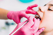 Orthodontist fixing girl's dental braces