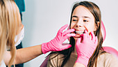 Orthodontist fixing girl's dental braces