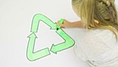 Girl colouring recycling symbol