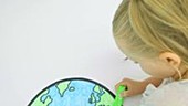 Girl colouring picture of earth