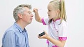 Girl putting makeup on her dad