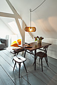 Sofa, armchair and dining area in open-plan attic interior