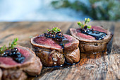 A winter barbecue: sliced elk roulade on a wooden board (Norway)