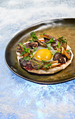 Natural cuisine: fried egg with chicken liver and wild mushrooms