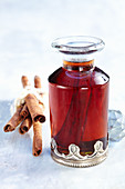 Cinnamon syrup in a decorative carafe with whole cinnamon sticks