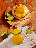 Homemade mango syrup with pancakes and limes