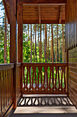 Balkon eines Landhauses mit Blick in den Kiefernwald