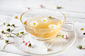 A cup of tea with daisies