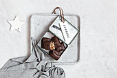Chocolate candy with nuts and dates in gift box on white marble background