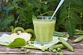 A green smoothie made with peas and kiwis