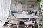 Weißer Holzpavillon mit Sitzecke und nostalgischer Dekoration