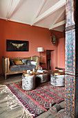Antique, gilt couch and side tables in room with salmon-pink walls