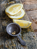 Lemons slice and stainer placed on wooden board