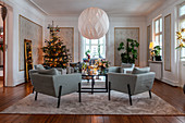 Elegantes Wohnzimmer mit Weihnachtsbaum und blauen Sesseln