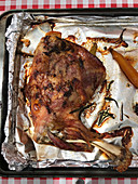 Roasted milk-reared lamb shoulder on a baking tray