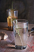 Glass of cool alcohol beverage with rosemary