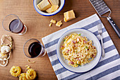 Homemade pasta Carbonara with parmesan cheese and a glass of red wine