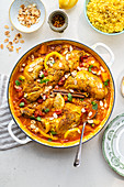 Moroccan chicken casserole with bowl of couscous on the side