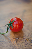 Eine Tomate auf Holzuntergrund