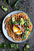 Waffels with bacon, cheese, chili, poached eggs. avocado and koriander