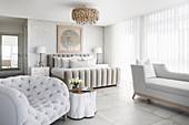 Upholstered furniture in luxurious bedroom in white and pale grey