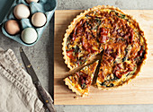 Proscuitto and Swiss Chard Tart on wooden chopping board